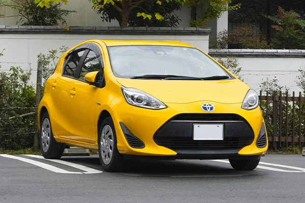 Yellow Toyota Prius C hybrid in parking spot