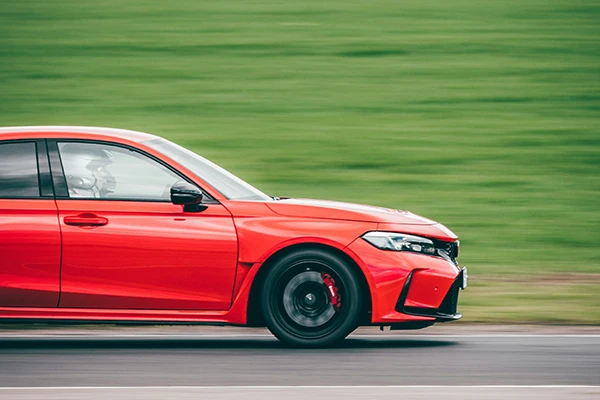 A red Honda Civic quickly driving by 